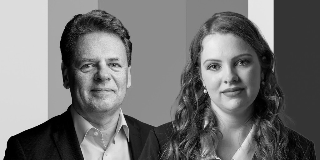 Black and white portrait of two professionals, a man and a woman, both dressed in formal attire, set against a gradient background.